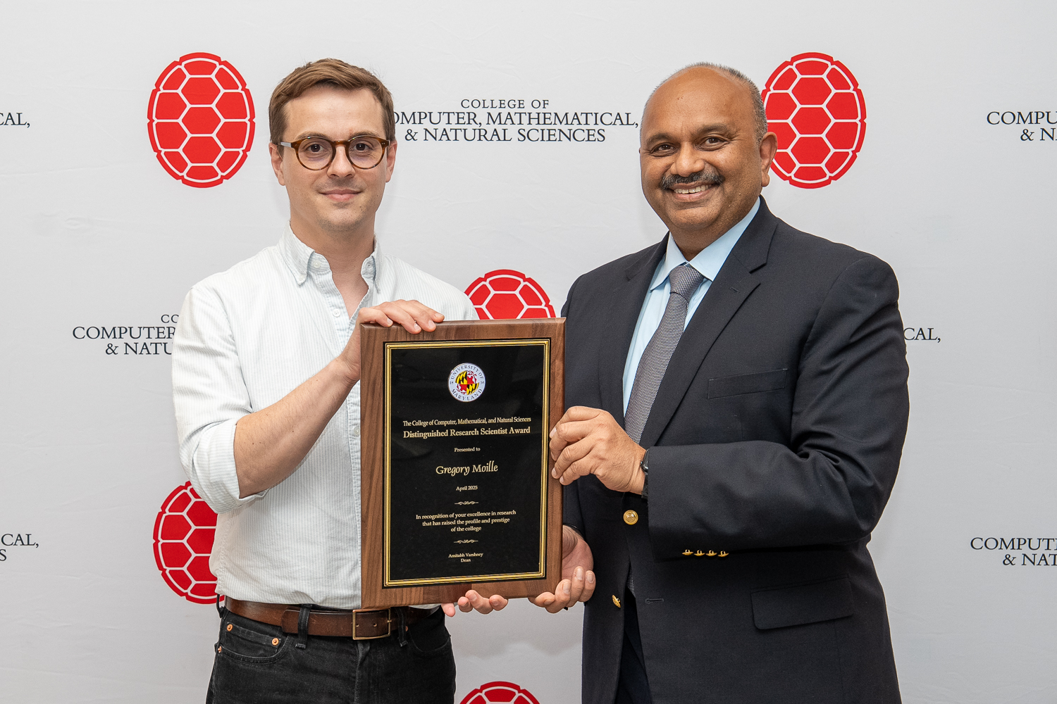 Gregory Moille and Amitabh Varshney holding plaque in front of CMNS branded backdrop
