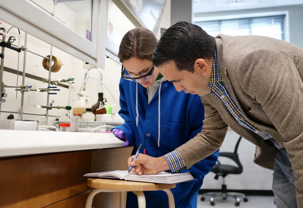 Osvaldo Gutierrez helping a student in the lab