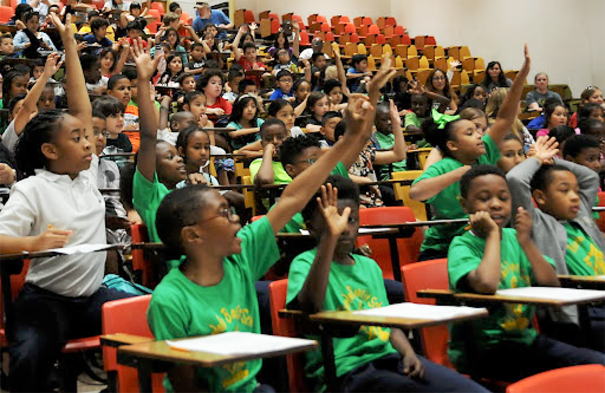 Grade school children raising their hands at Kids and Chemistry