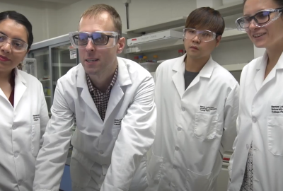 Dr. Peter Nemes and other researchers gathered around a computer. 