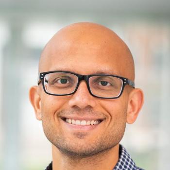 Pratyush Tiwary in glasses and a blue-checked shirt.