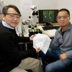 Researchers Yuhuang Wang and Min Ouyang holding newly developed fabric
