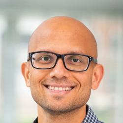 Pratyush Tiwary in glasses and a blue-checked shirt.