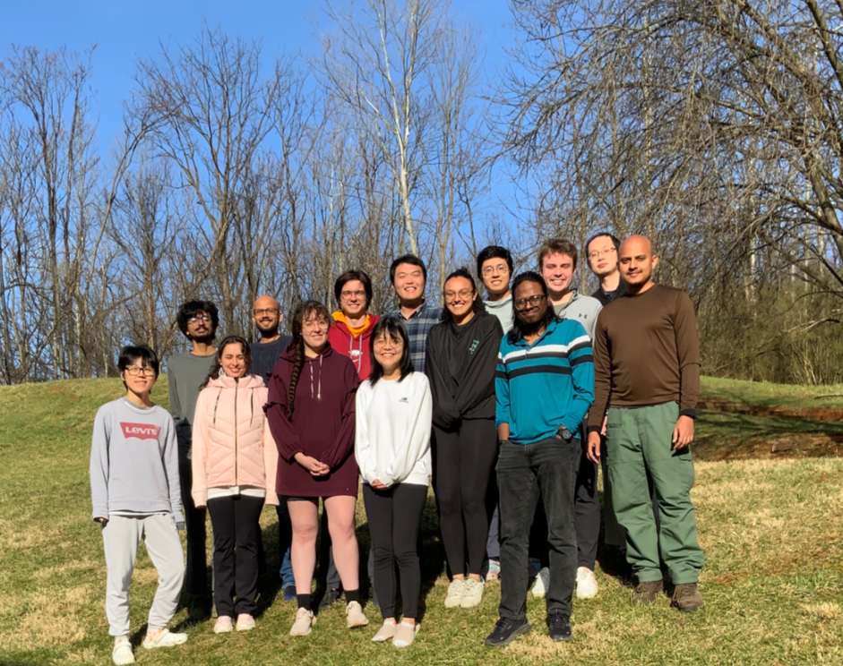 A team of researchers posing as a group in a field.